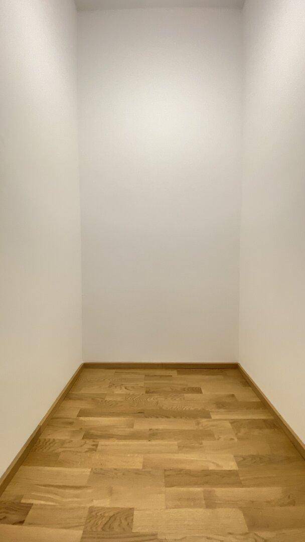 Kleiner, leerer Abstellraum mit hellem Parkettboden und weißen Wänden, vielseitig nutzbar.