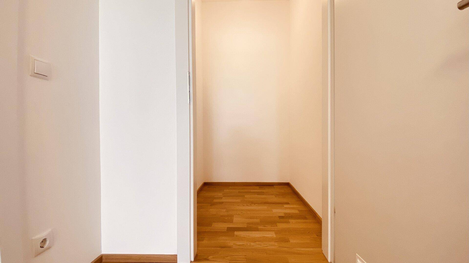 Kleiner Abstellraum mit Parkettboden, ideal für zusätzlichen Stauraum oder als begehbarer Kleiderschrank.