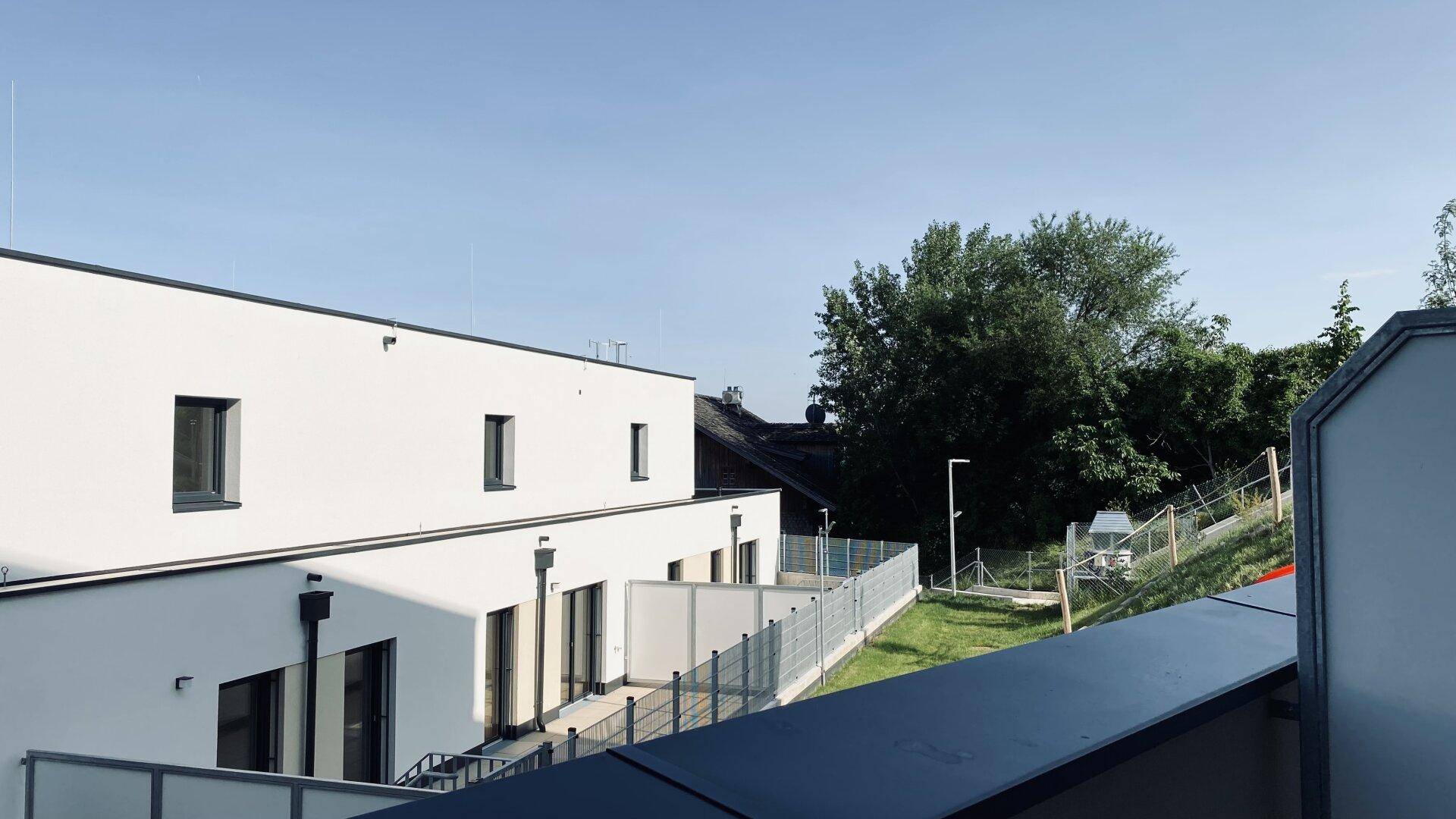 Moderne Wohngebäude mit Flachdächern und Grünflächen in einer ruhigen Umgebung.