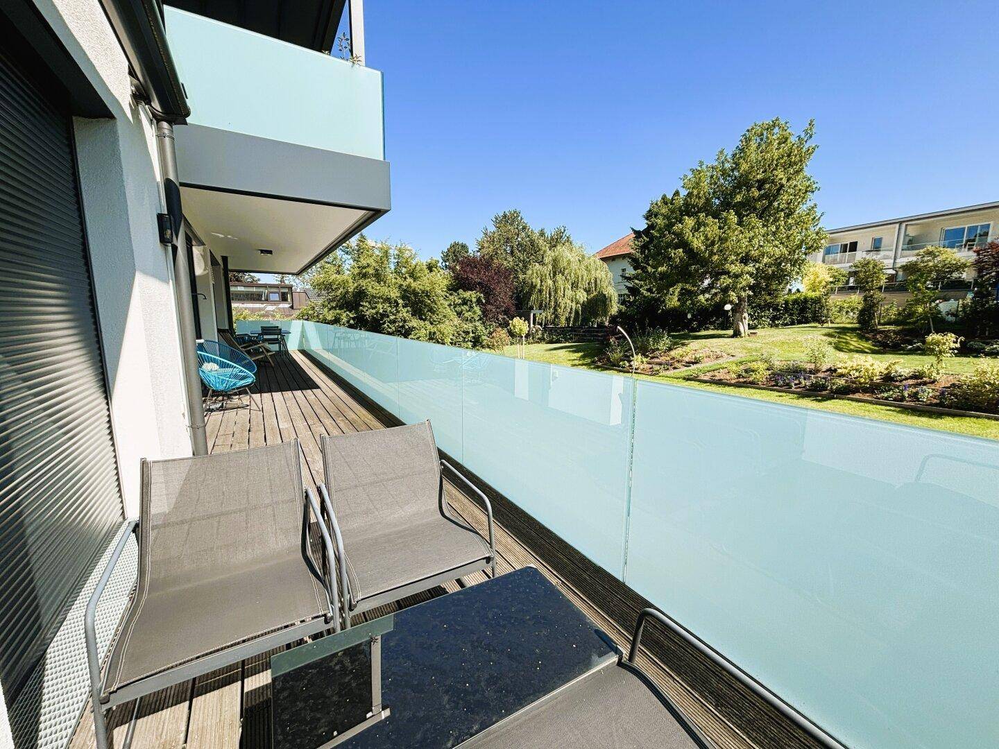 Geräumiger Balkon mit Sitzgelegenheiten und Blick ins Grüne.
