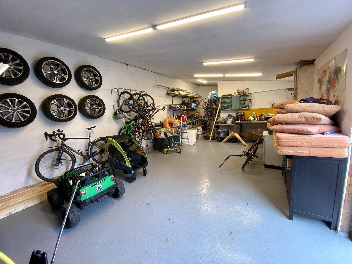 Geräumige Garage mit vielen Reifen, Fahrrädern und Lagerflächen.