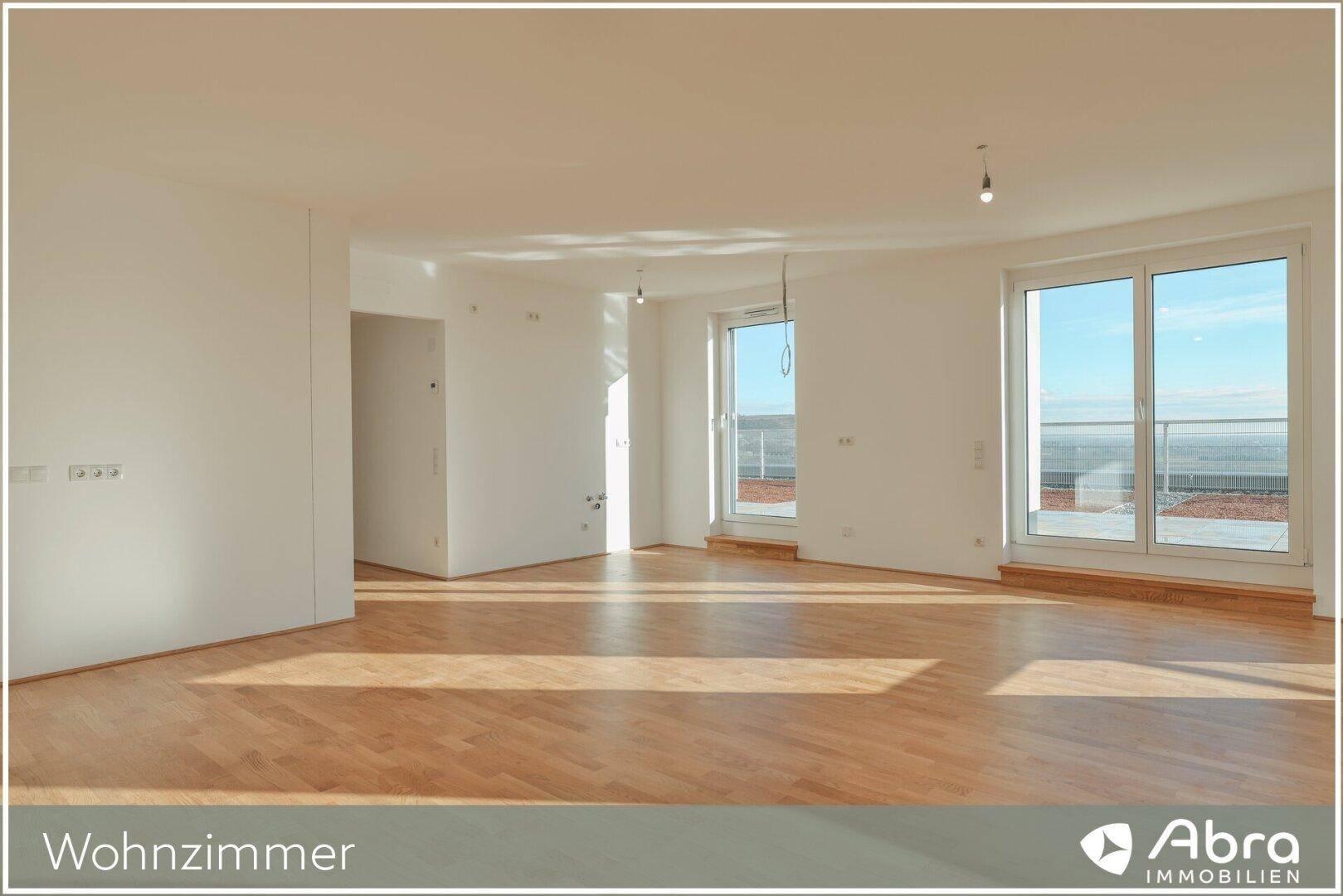 Geräumiges Wohnzimmer mit hellem Holzboden und großen Fenstern, die viel Tageslicht hereinlassen.