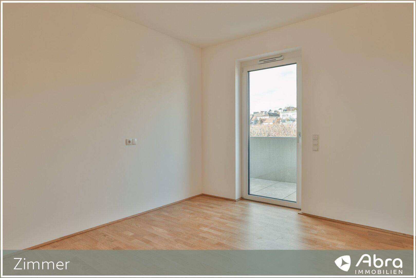 Ruhiges Zimmer mit Parkettboden und einem großen Fenster, das viel Tageslicht in den Raum bringt.