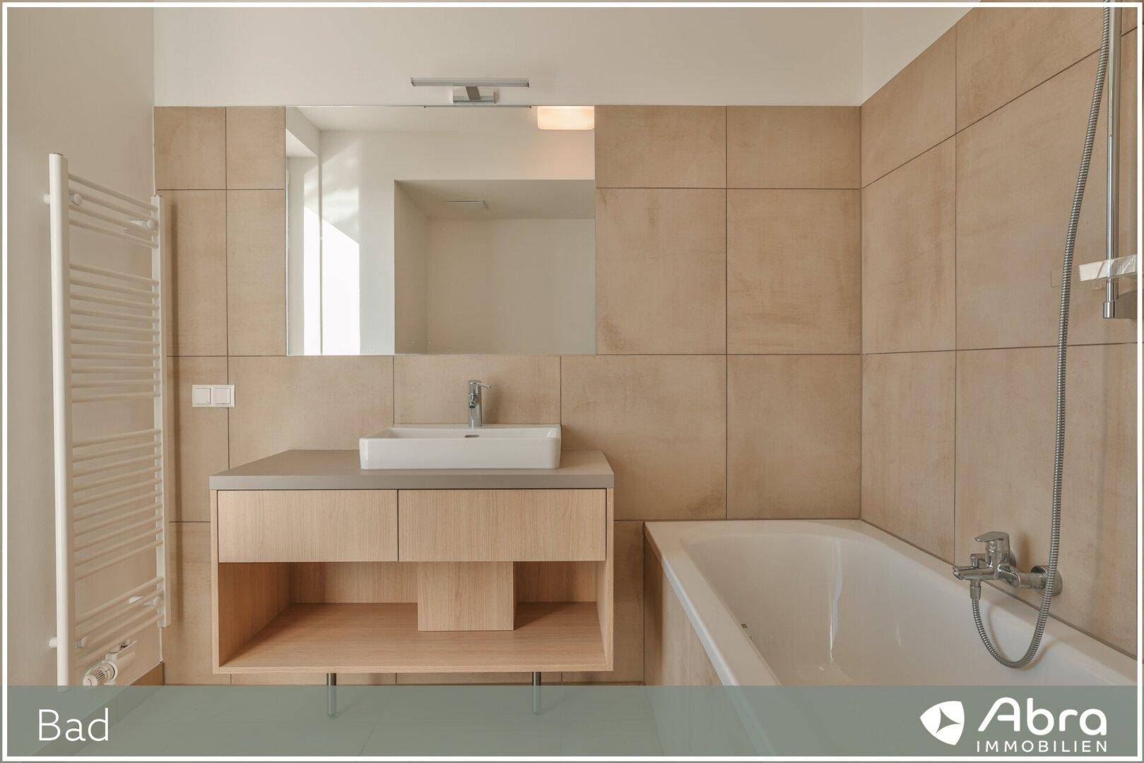 Elegantes Badezimmer mit modernem Waschtisch, großem Spiegel, Badewanne und Handtuchheizkörper.