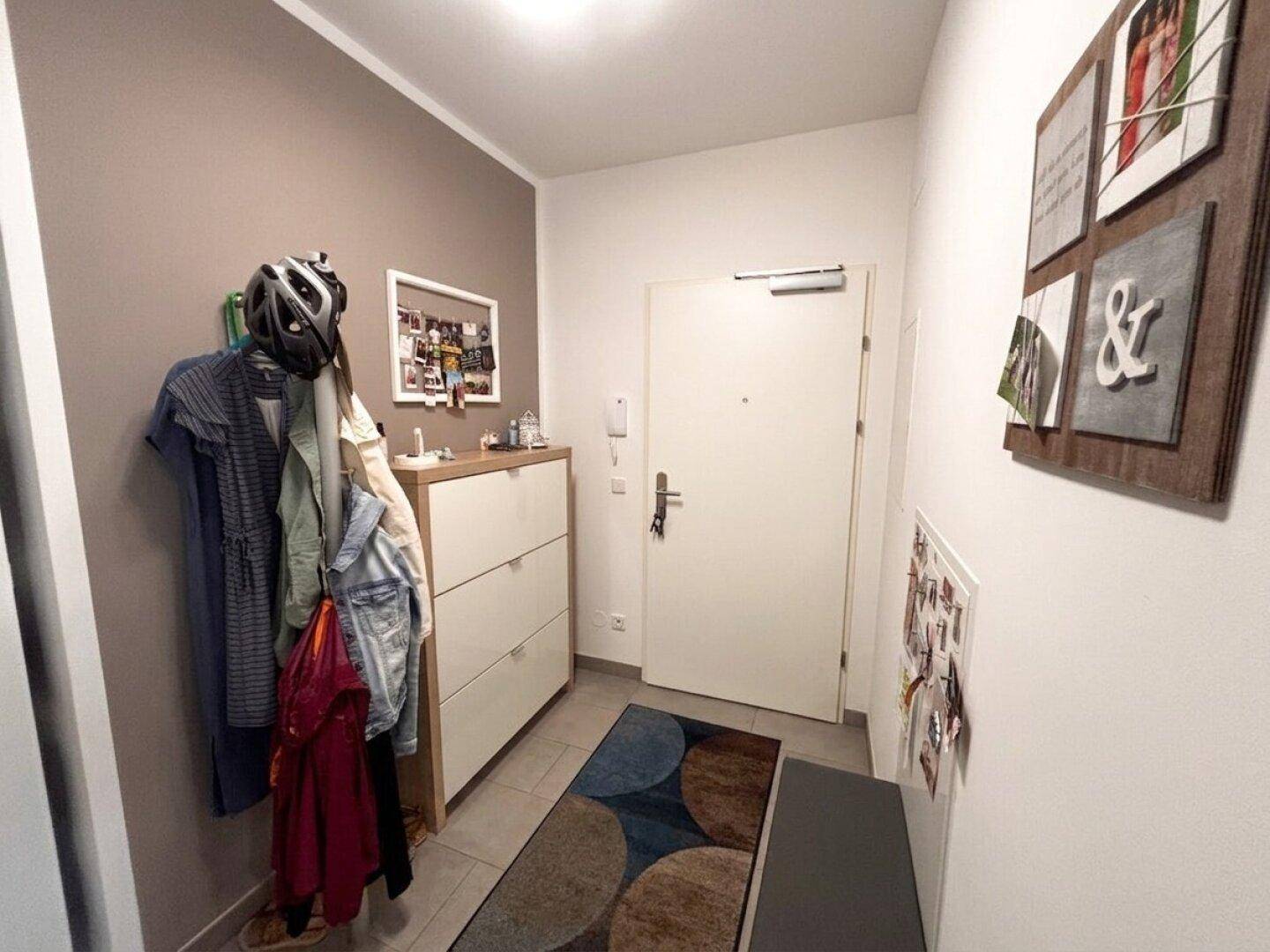 Eingangsbereich mit Schuhschrank, Garderobe und heller Eingangstür.