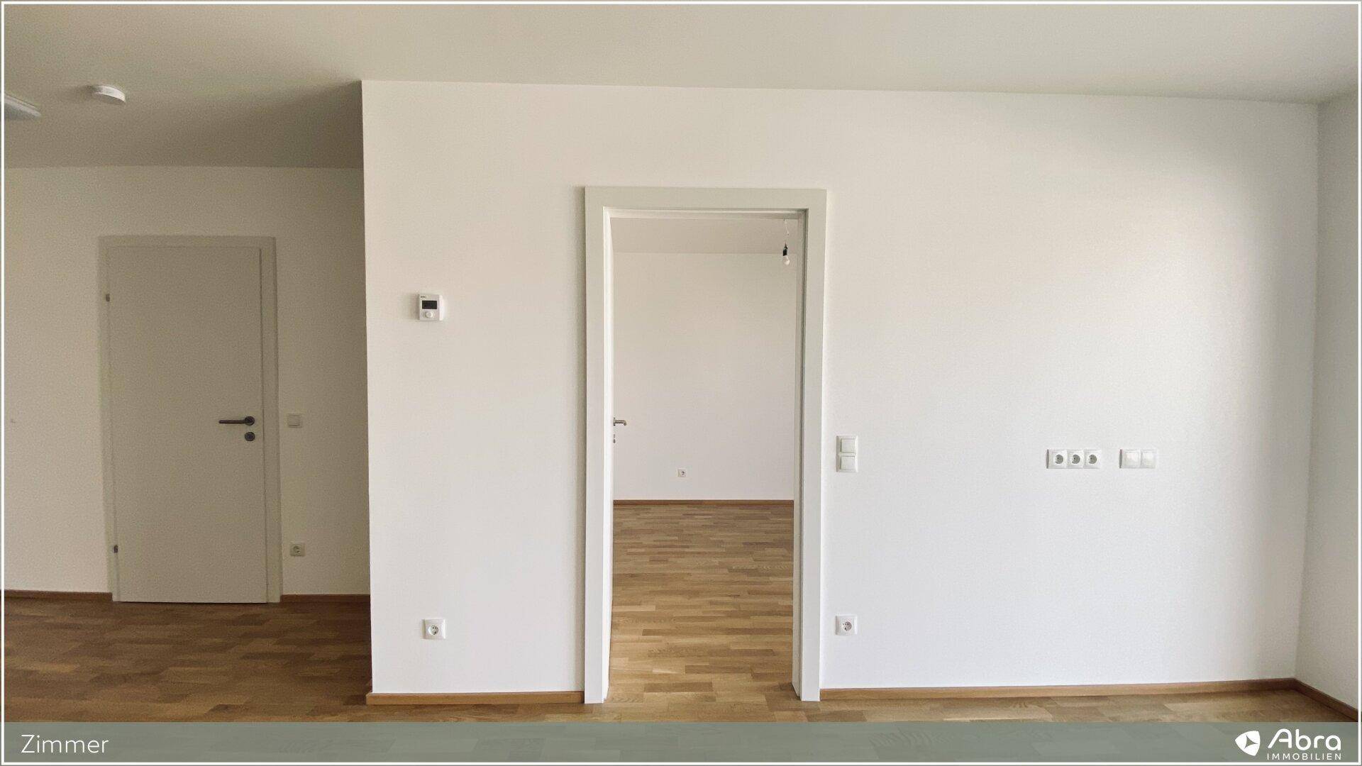 Heller Raum mit Holzboden und zwei Türen, bietet flexible Nutzungsmöglichkeiten.