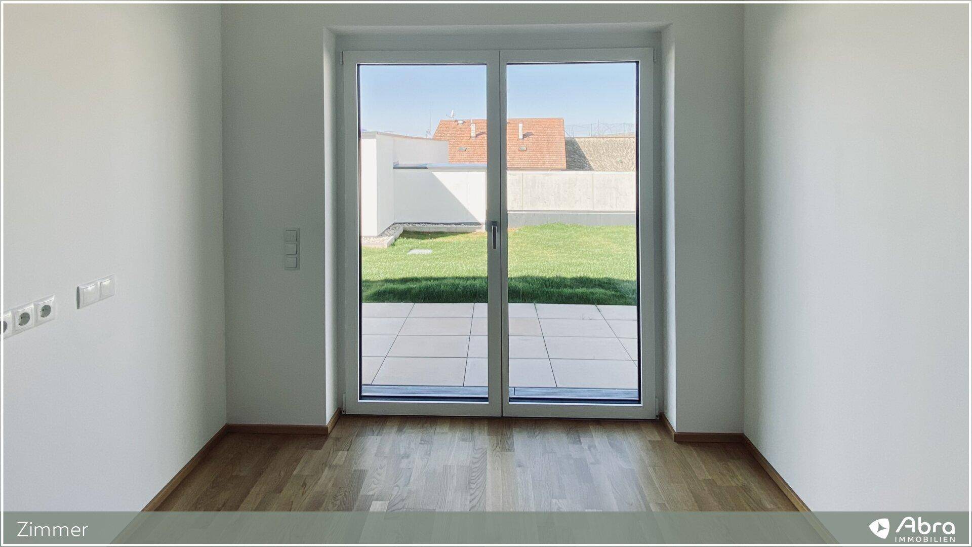 Lichtdurchfluteter Raum mit großen Schiebetüren zum Garten und Terrasse, ideal für Wohnzwecke.