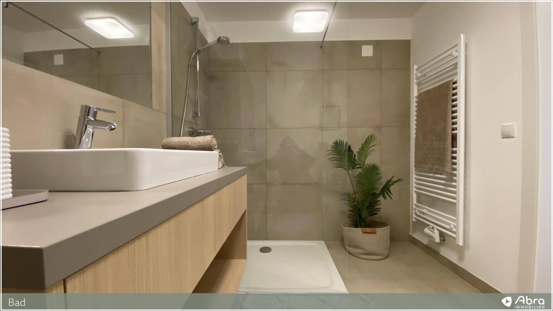 Helles Badezimmer mit begehbarer Dusche, beheiztem Handtuchhalter und modernem Design.