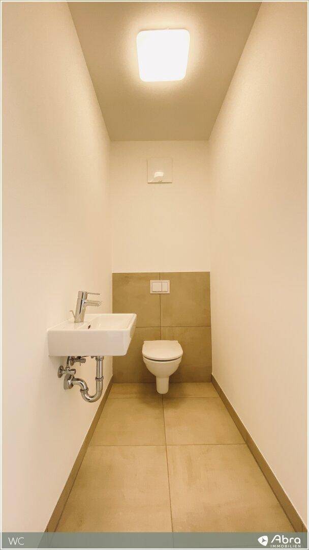 Kleines Gäste-WC mit Wand-WC und Handwaschbecken, in modernem und funktionalem Design.