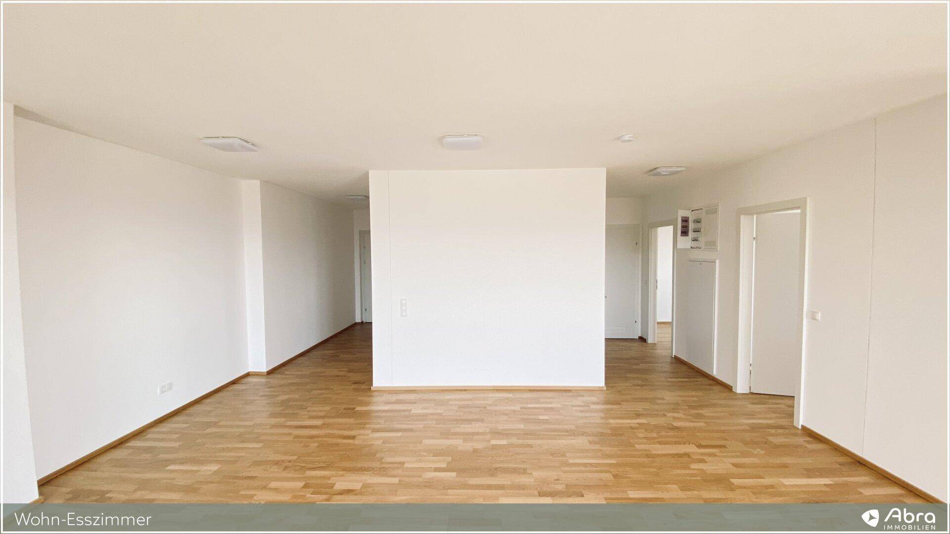 Offener Wohn-Essbereich mit hellem Parkettboden und klaren Linien, ideal für moderne Einrichtung.