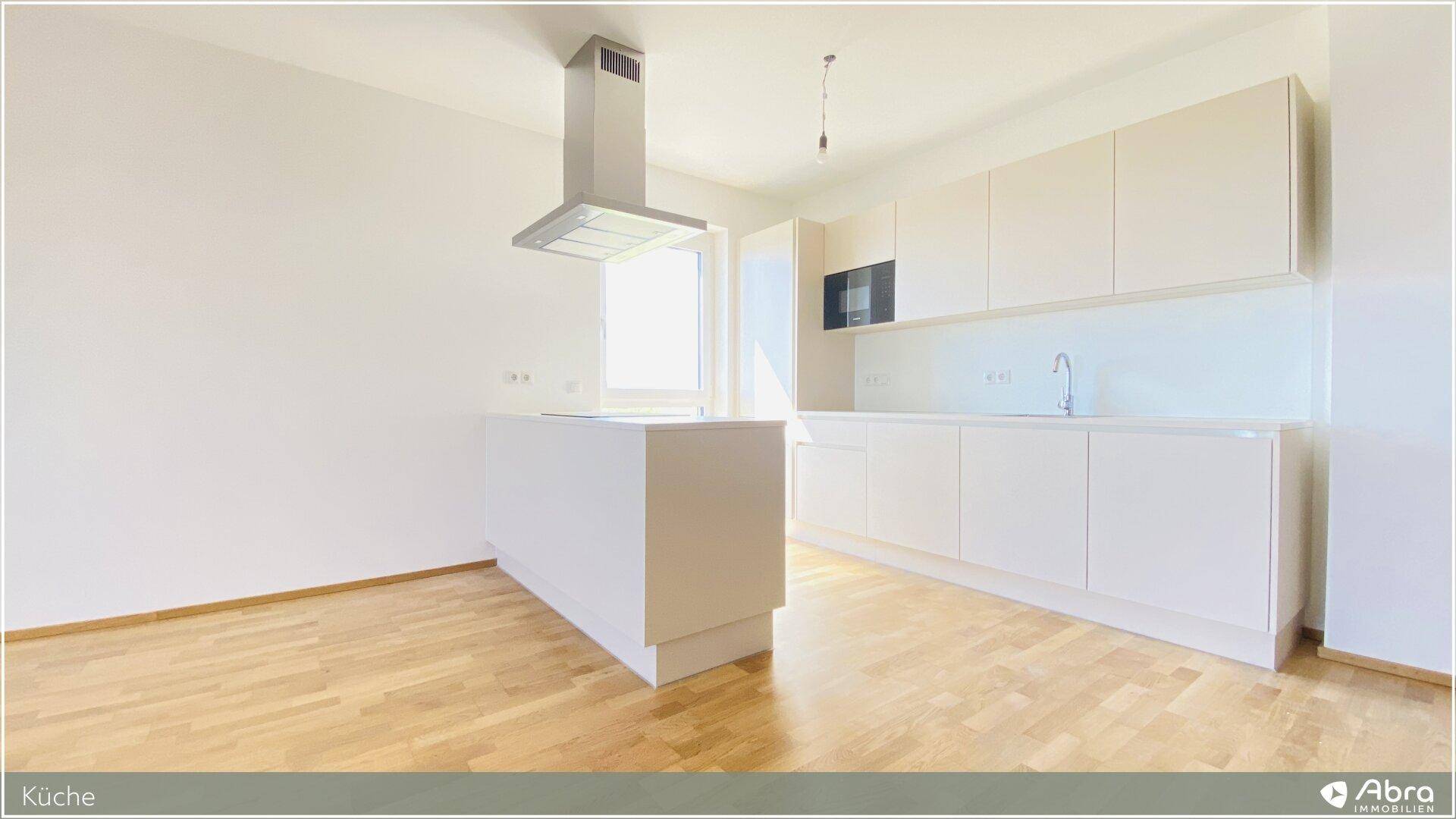 Moderne Einbauküche mit heller Kücheninsel, Dunstabzugshaube und Parkettboden.