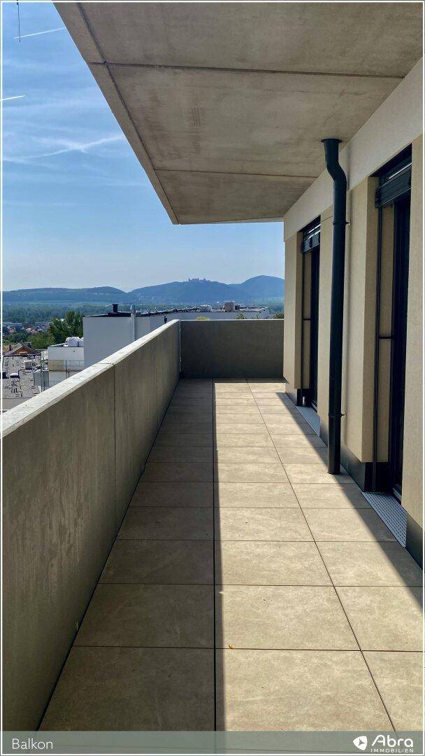 Geräumiger Balkon mit Fliesenboden und Betonbrüstung, bietet einen schönen Bergblick.