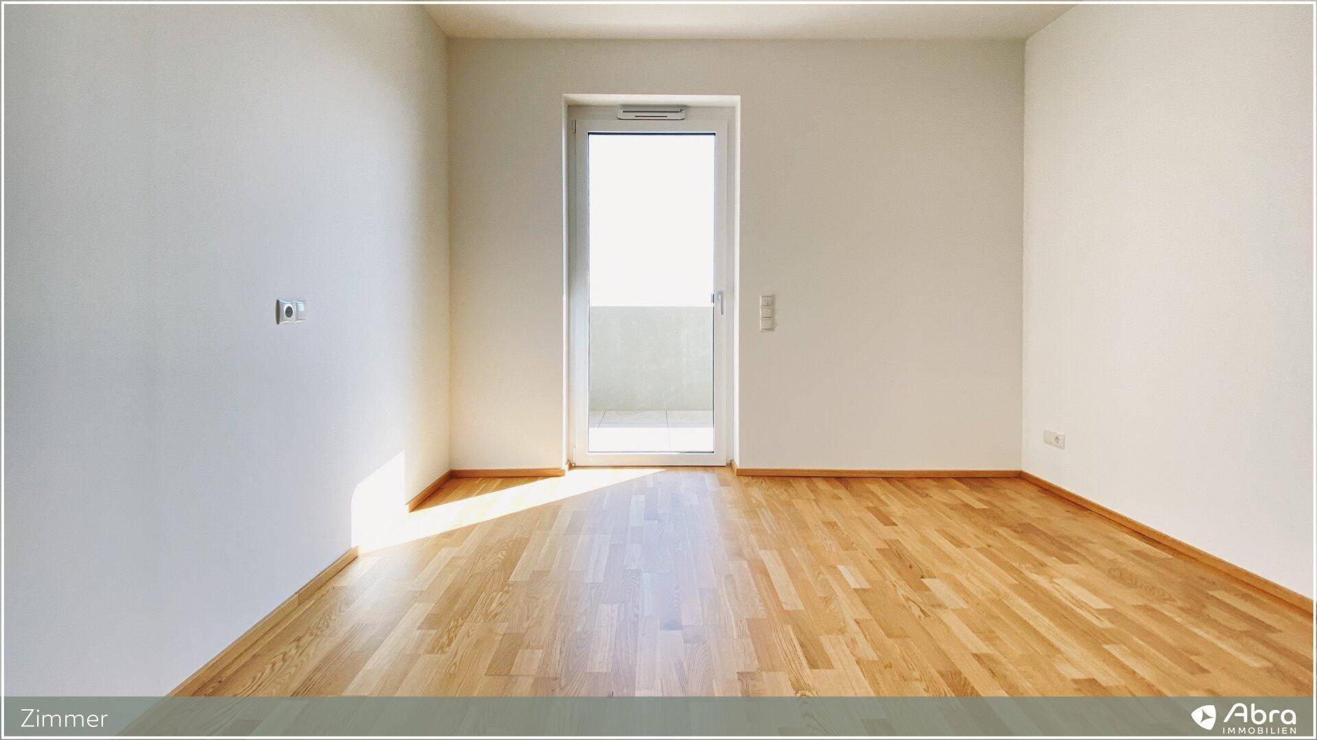 Sonniger Raum mit Parkettboden und Balkontür, ideal als Schlaf- oder Arbeitszimmer.