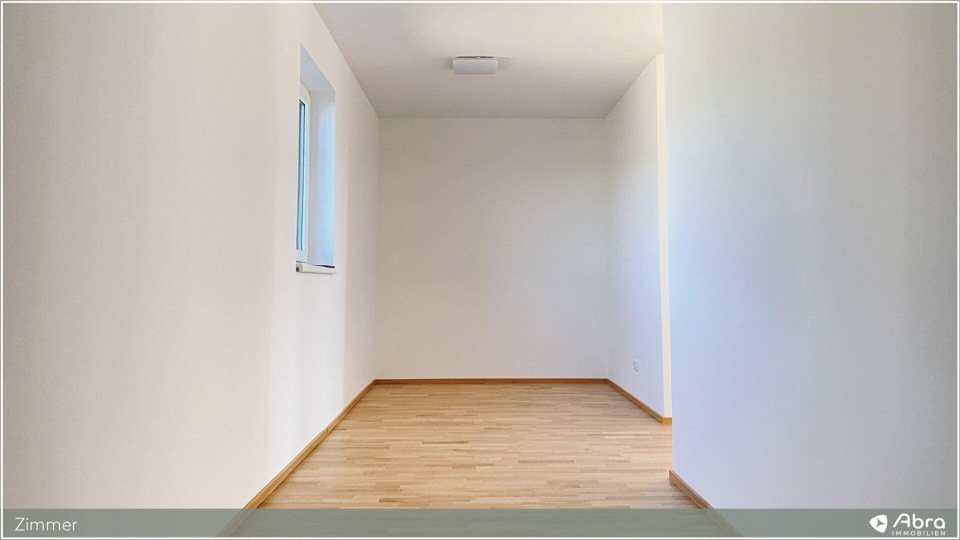 Helles, leeres Zimmer mit Parkettboden und einem Fenster, ideal als Schlaf- oder Arbeitszimmer.