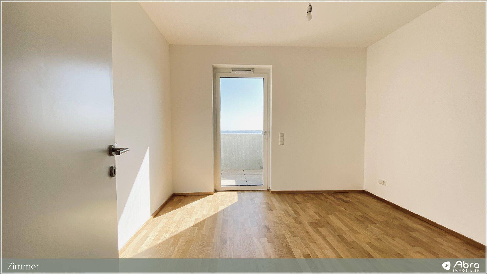Unmöbliertes Zimmer mit Parkettboden und Balkontür, bereit für individuelle Gestaltung und Nutzung.