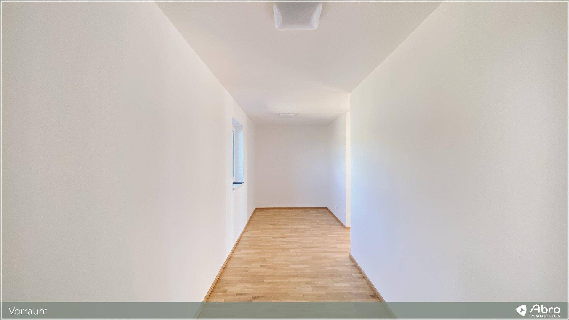 Heller Vorraum mit Parkettboden und Fenster, der zu den Wohnbereichen führt.