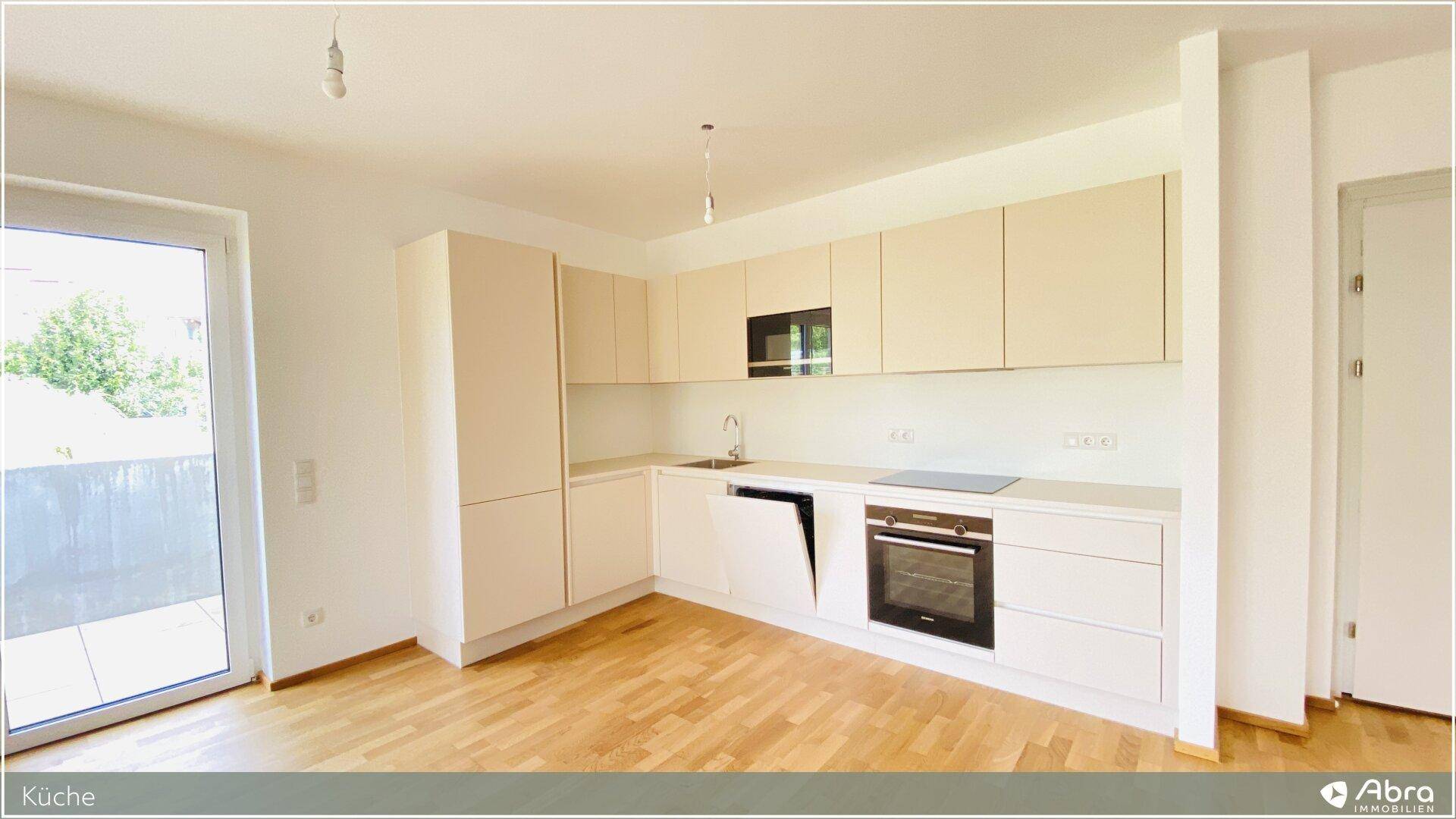 Funktionale Einbauküche in hellem Design mit modernen Geräten und Holzboden.