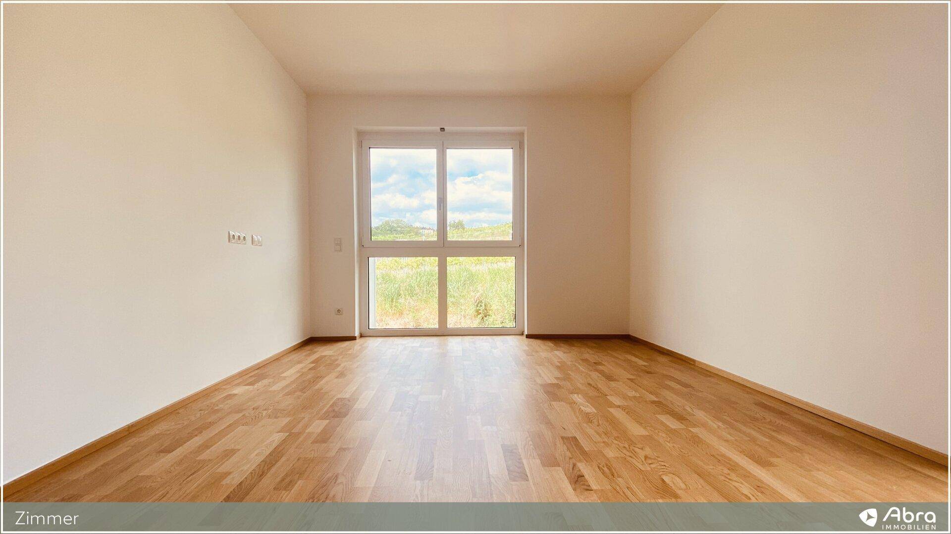 Geräumiges Zimmer mit Parkettboden und weitem Blick auf die umliegende Natur.
