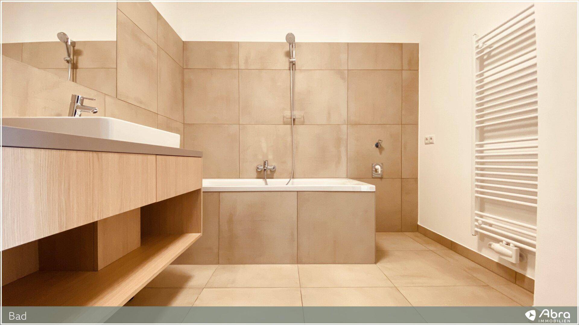 Helles Badezimmer mit Badewanne, Duschfunktion und praktischem Handtuchheizkörper.