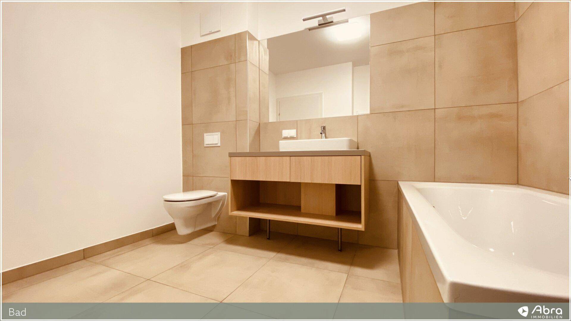 Stilvolles Badezimmer mit Wand-WC, modernem Waschtisch und Badewanne, in neutralen Farbtönen.