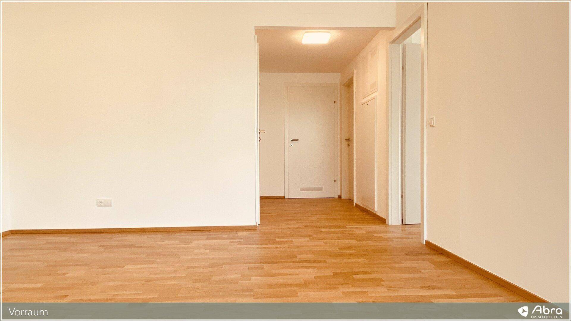 Heller Vorraum mit Holzboden, der zu den verschiedenen Zimmern der Wohnung führt.