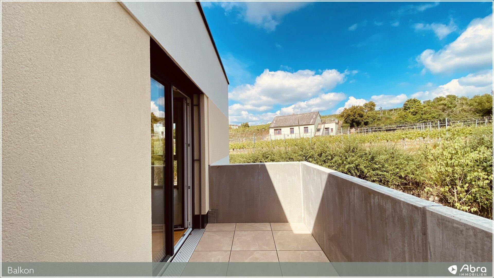 Moderner Balkon mit Fliesenboden und weitem Blick auf Weinberge und Landschaft.