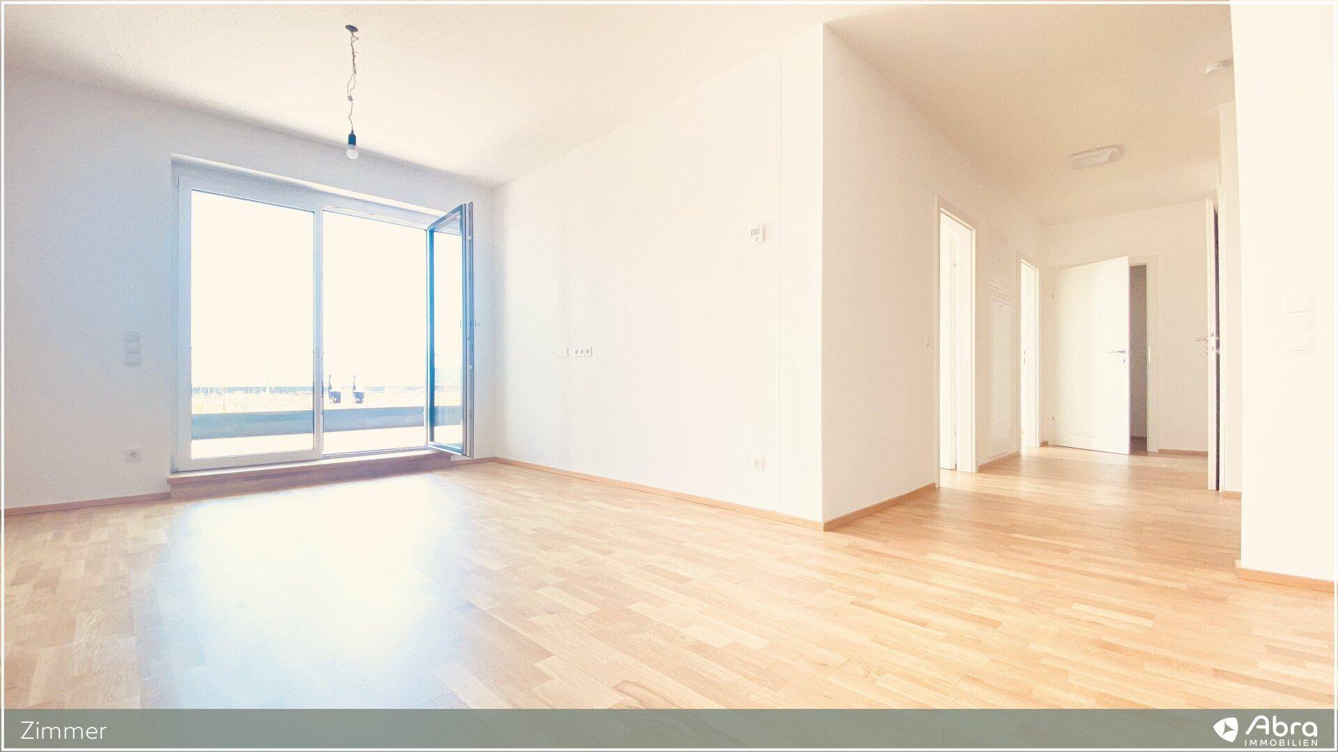 Lichtdurchflutetes Zimmer mit Holzboden und Zugang zu einem Außenbereich, ideal als Wohnzimmer.