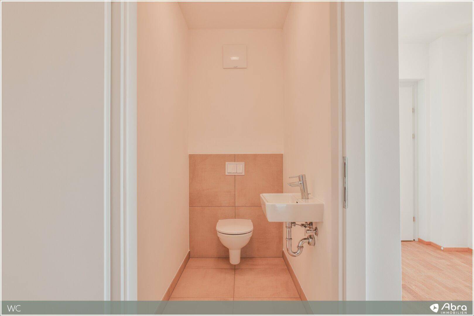 Kompaktes Gäste-WC mit Wand-WC und kleinem Handwaschbecken, funktional und hell.
