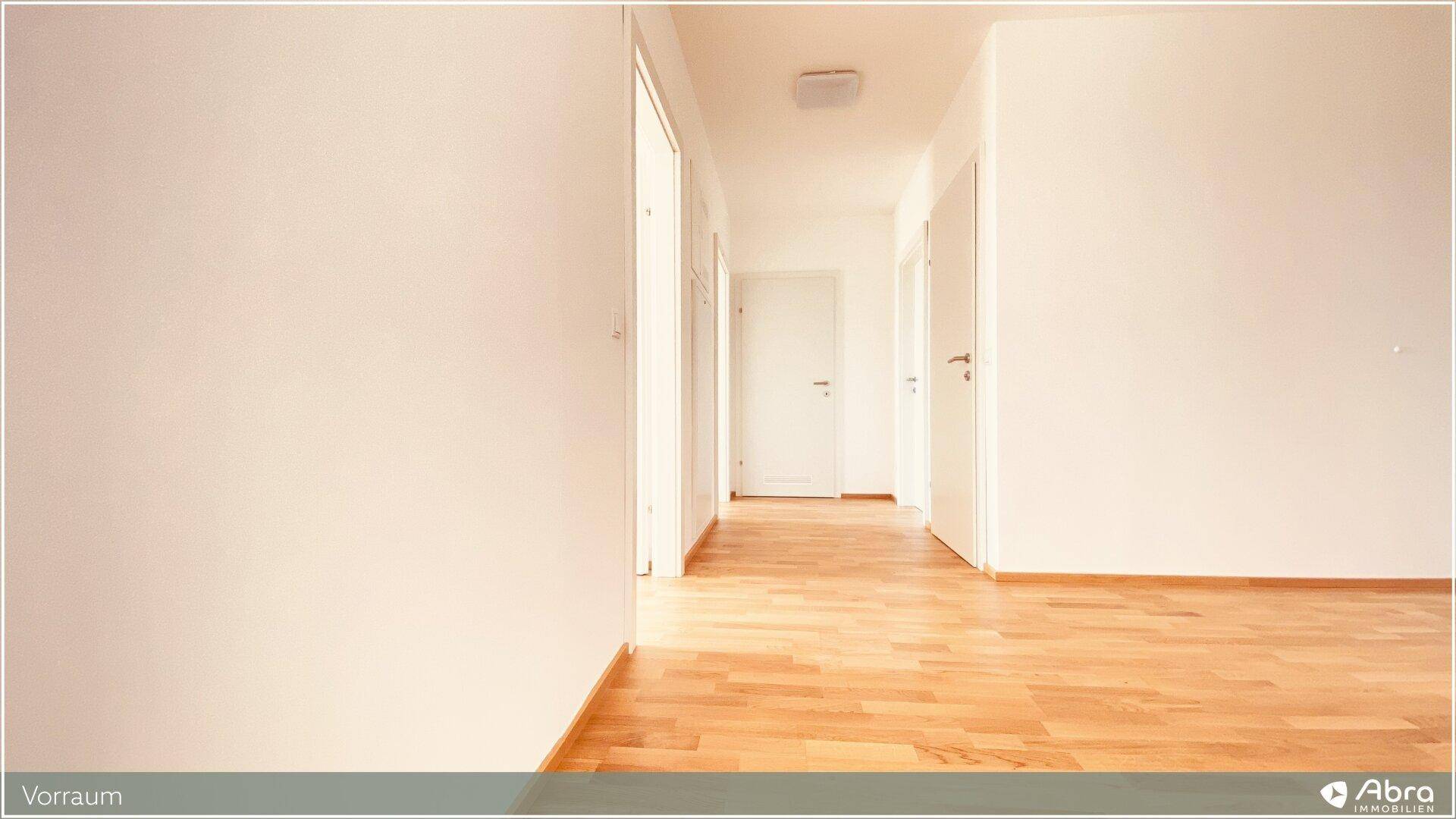 Heller Flur mit Parkettboden, der zu verschiedenen Zimmern der Wohnung führt.