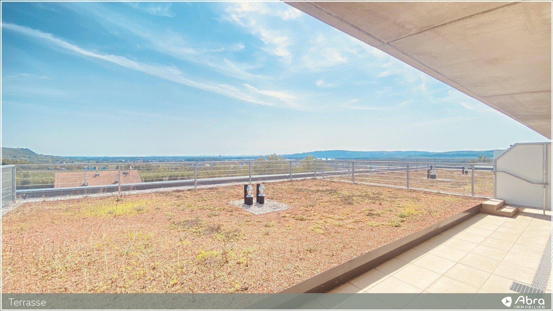 Weitläufige Terrasse mit Gründach und Panoramablick über die umliegende Landschaft.