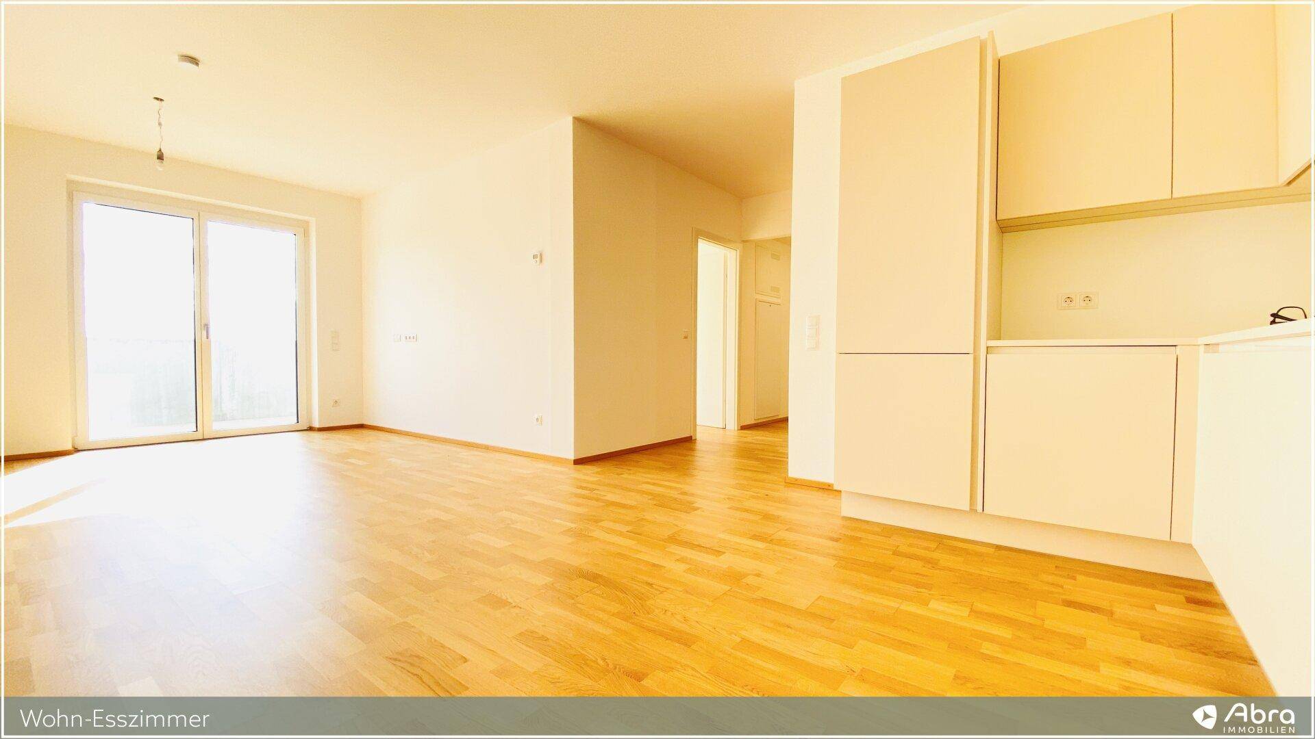 Heller Wohn-Essbereich mit Holzparkettboden und großem Fenster, bereit zur individuellen Gestaltung.