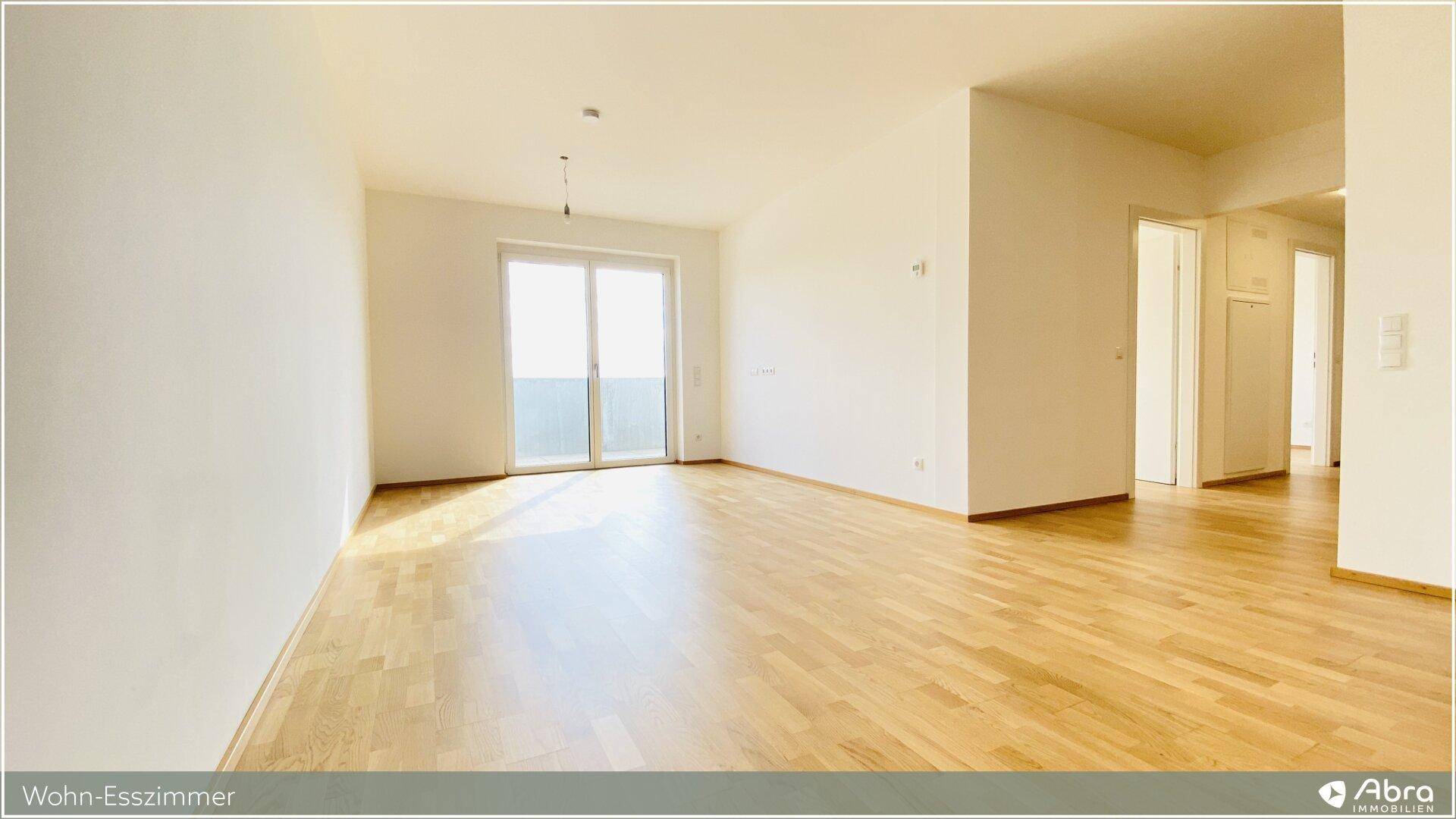 Geräumiger Wohn-Essbereich mit Parkettboden und viel Tageslicht, bietet flexible Einrichtungsmöglichkeiten.