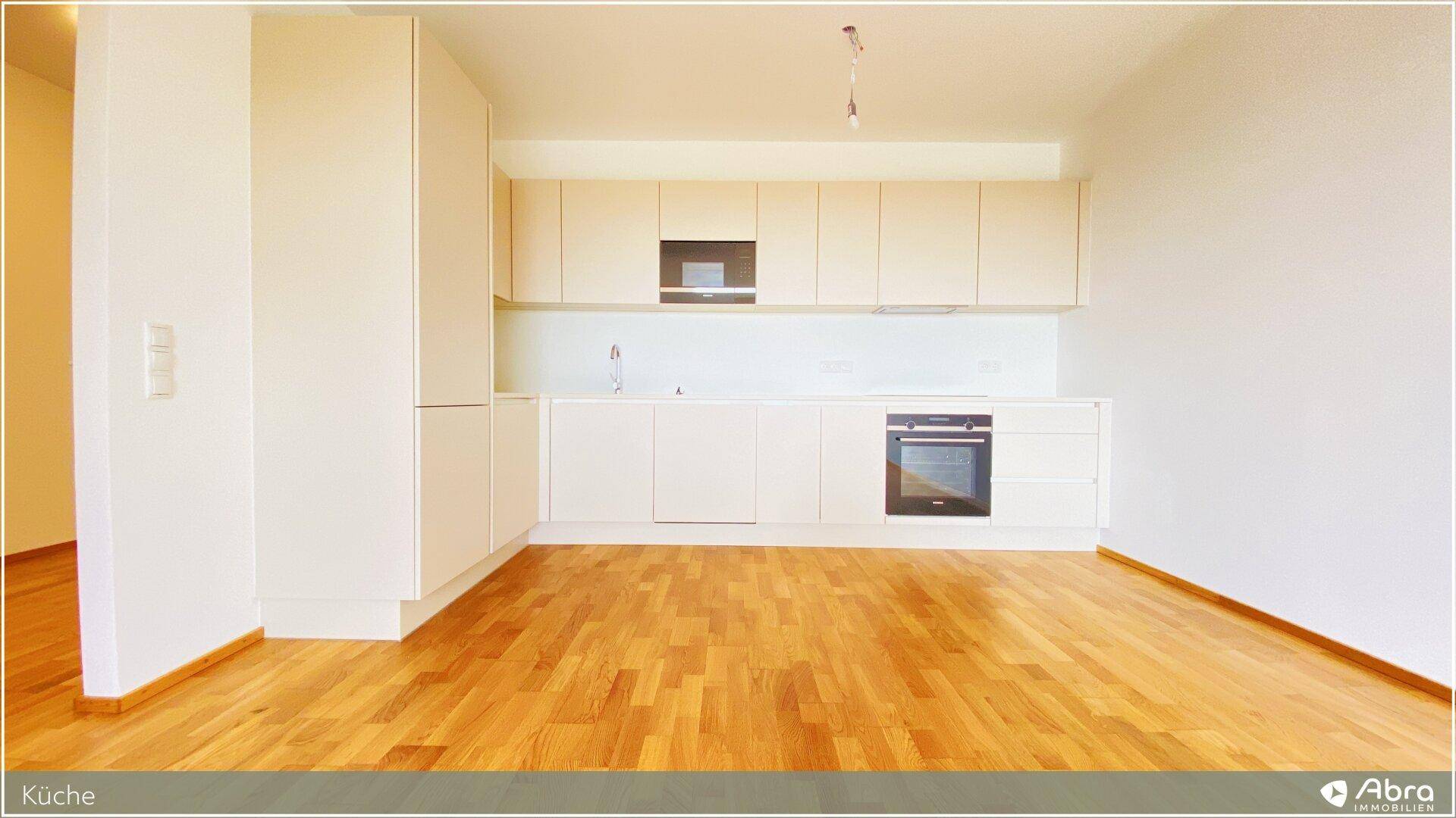 Moderne Einbauküche in hellem Design mit integriertem Backofen und viel Stauraum.