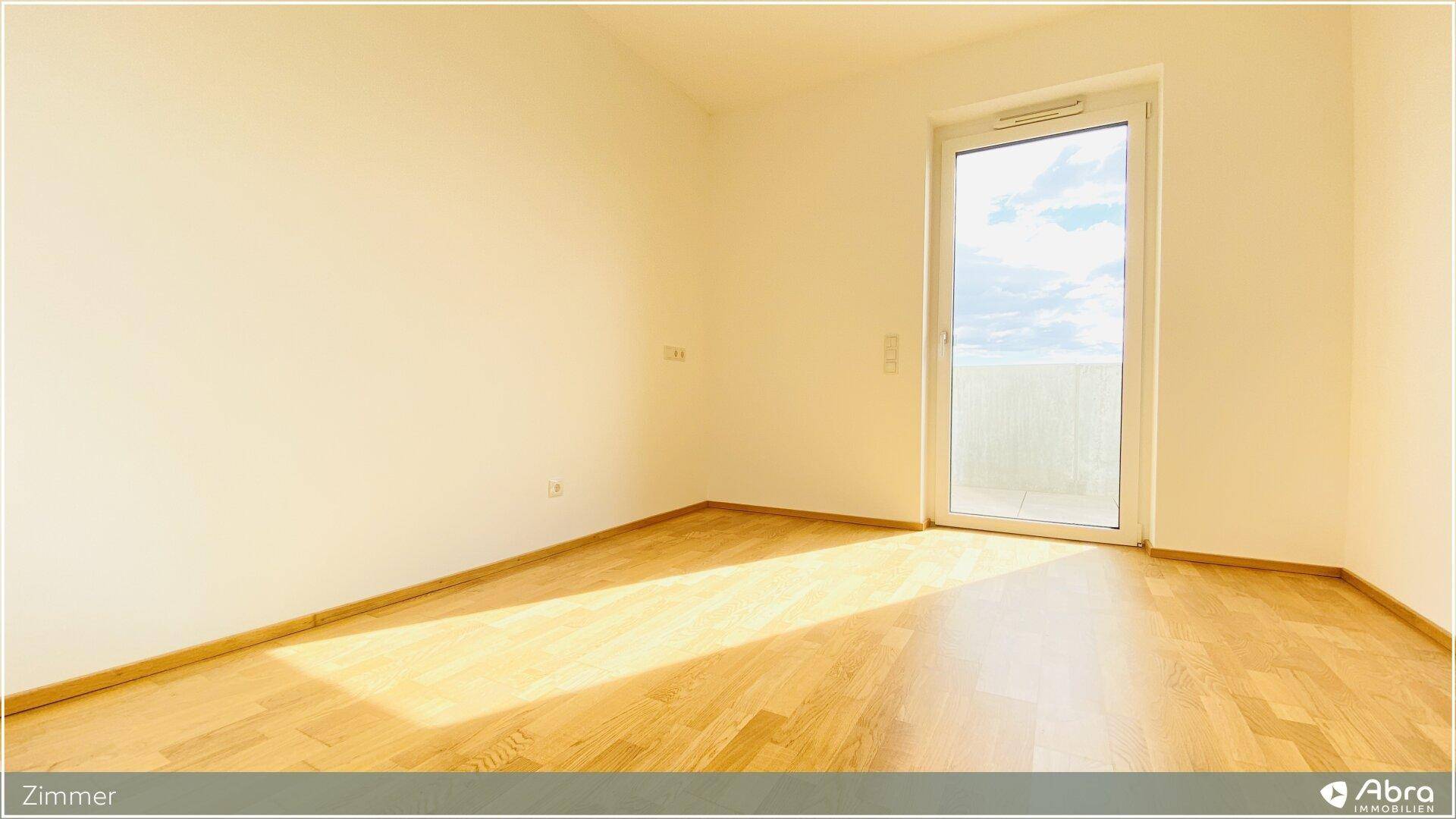 Sonniges Zimmer mit Holzboden und großem Fenster, ideal als Schlaf- oder Arbeitszimmer.