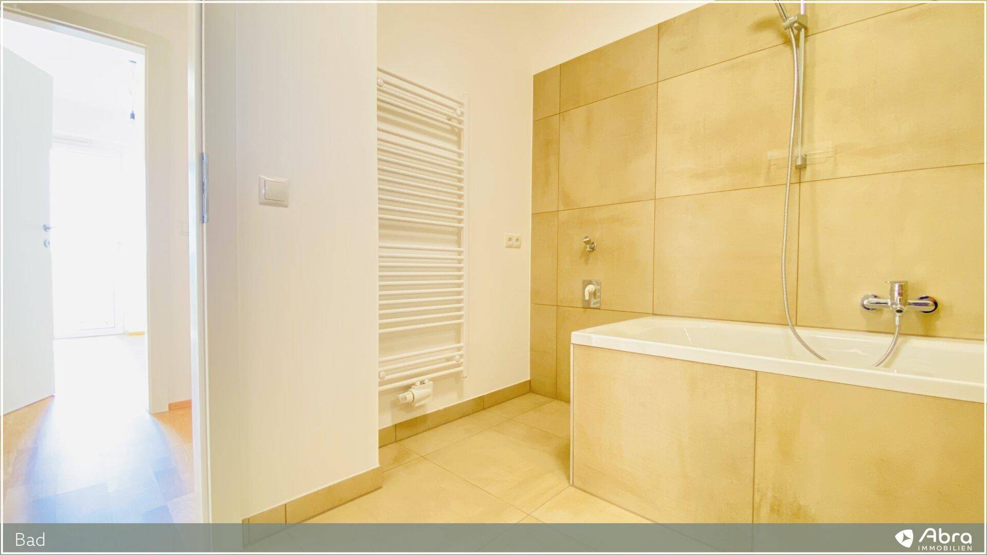 Funktionales Badezimmer mit Badewanne und beheiztem Handtuchhalter, in zeitlosem Design.