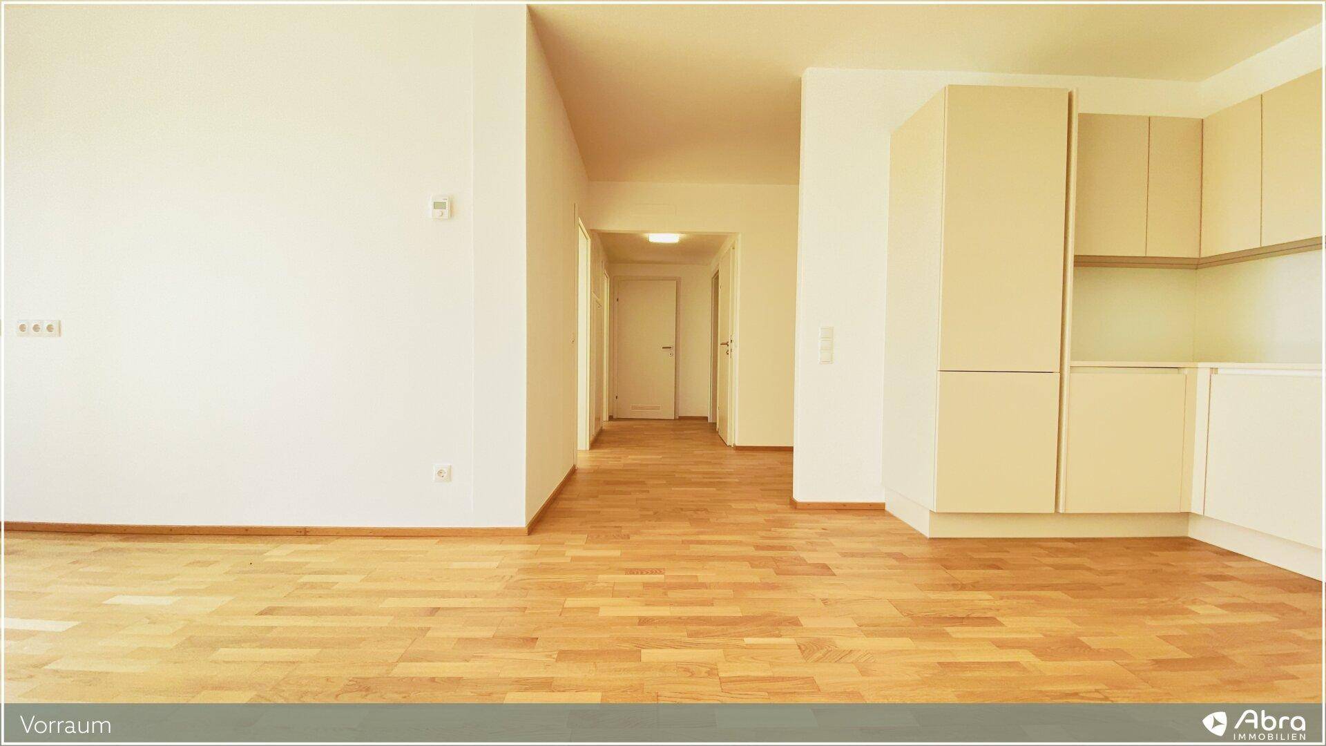 Heller Vorraum mit Parkettboden und Blick in den offenen Wohnbereich, einladend gestaltet.