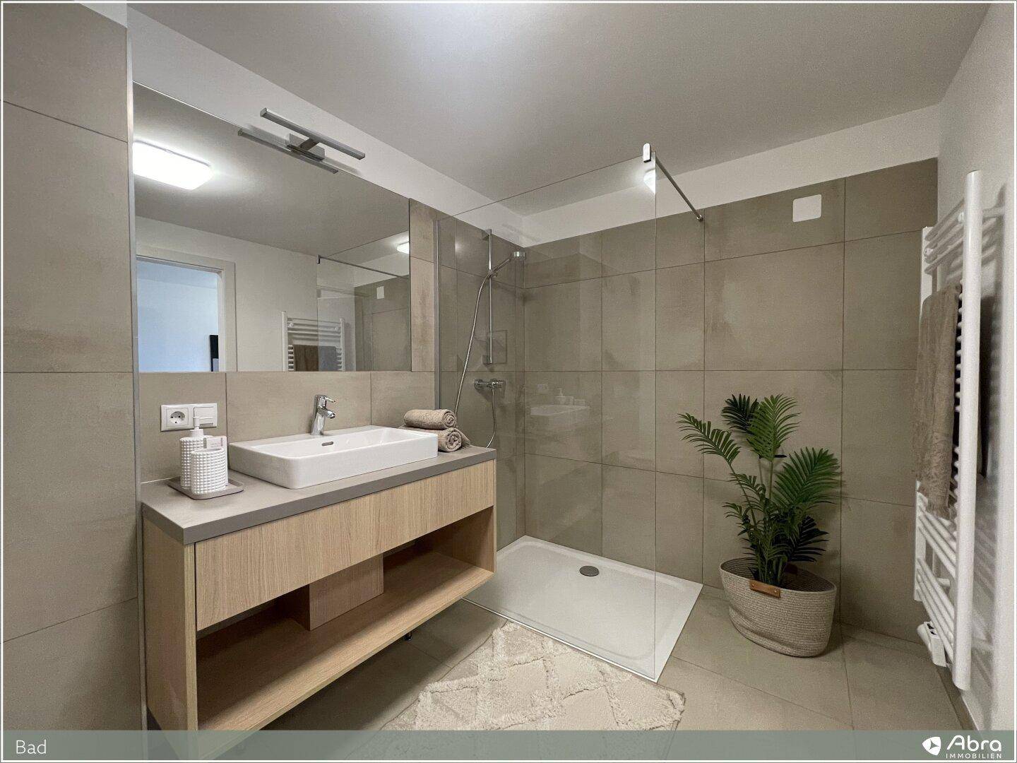 Modernes Badezimmer mit begehbarer Dusche, Einzelwaschbecken und beigefarbenen Fliesen, sehr gepflegt.