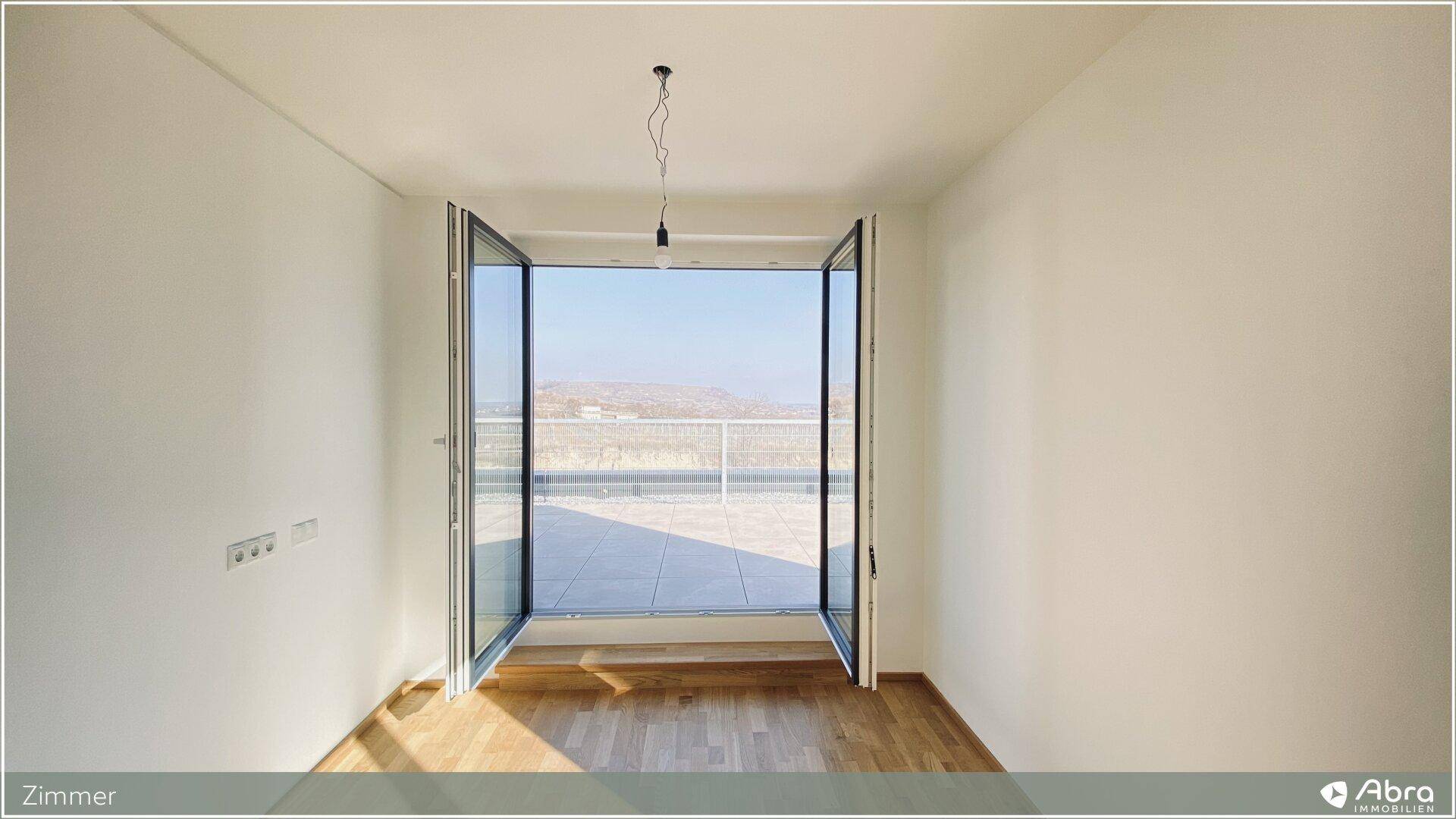 Geräumiges Zimmer mit Parkettboden und direktem Zugang zur sonnigen Terrasse.