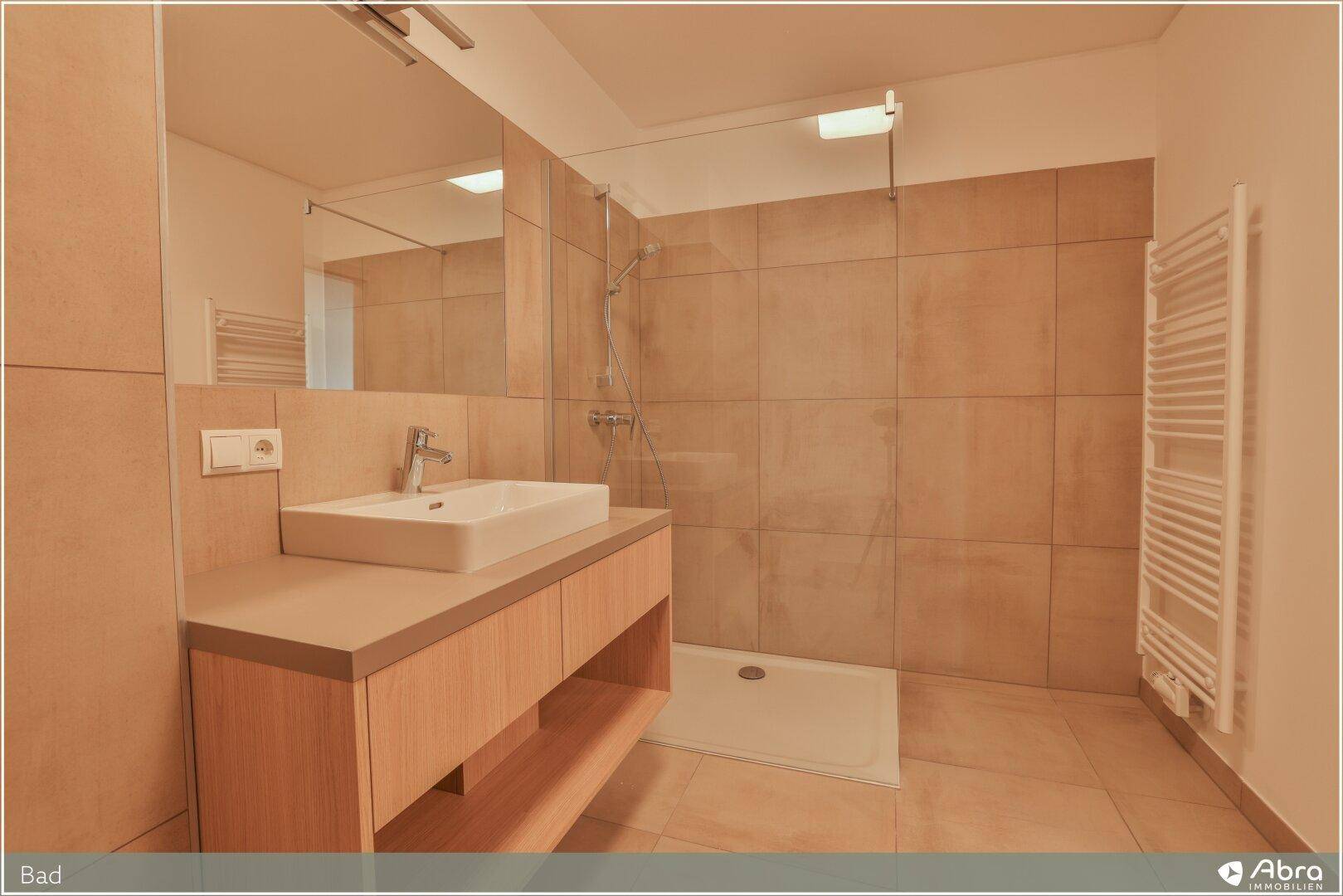 Modernes Badezimmer mit begehbarer Dusche, Einzelwaschbecken und beigefarbenen Fliesen.