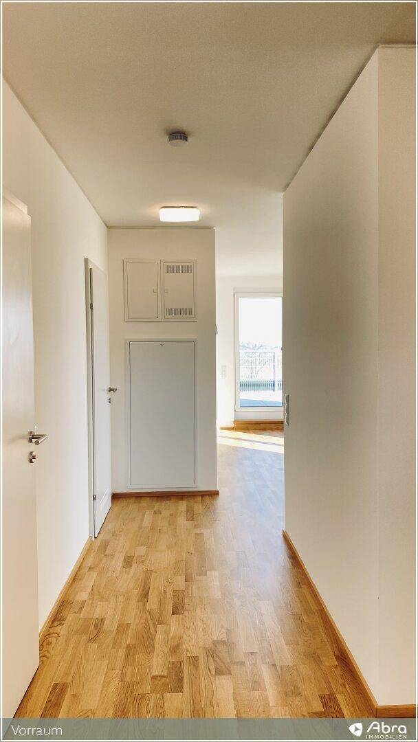 Heller Flur mit Parkettboden, der zu den verschiedenen Räumen der Wohnung führt.