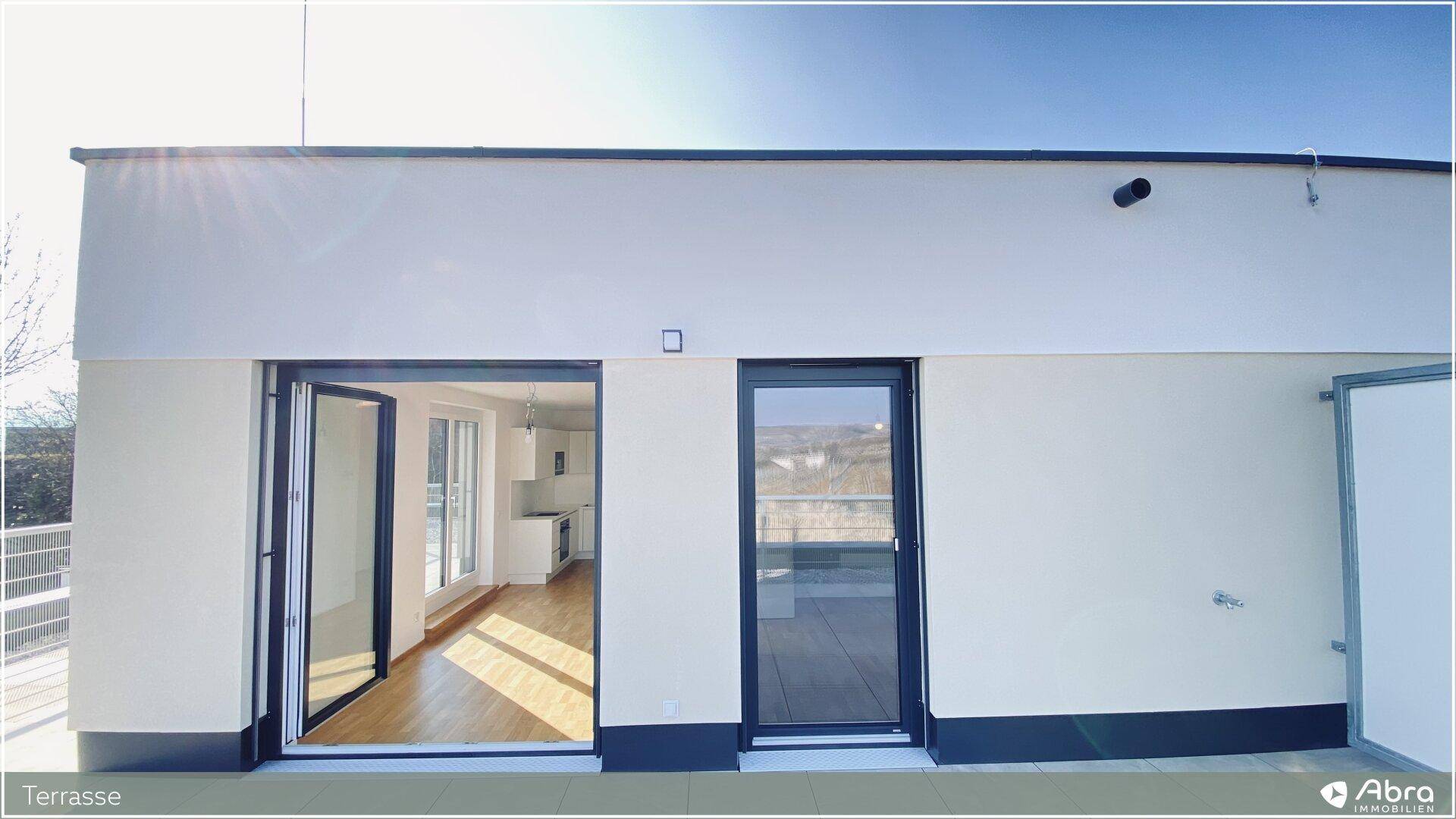 Moderne Fassade mit großen Terrassentüren, die den Zugang zum Außenbereich ermöglichen.