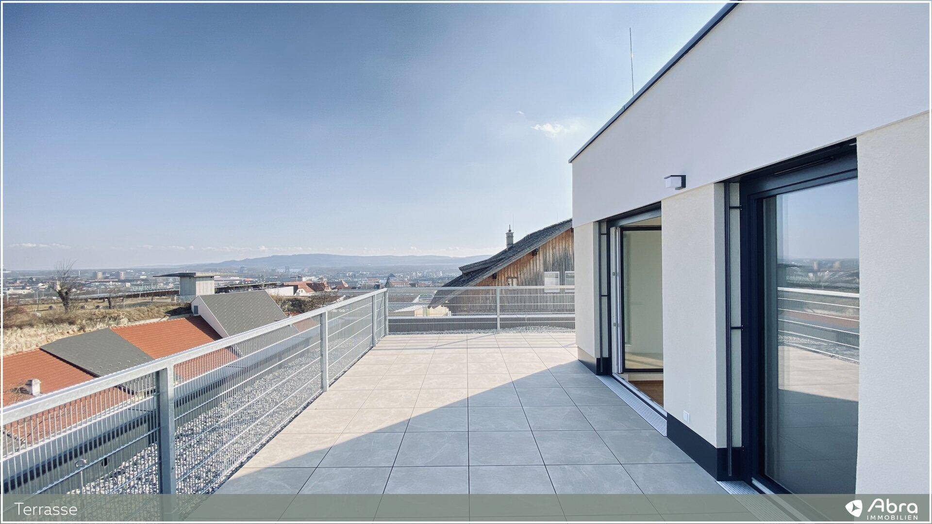 Weitläufige Terrasse mit Fliesenboden und beeindruckendem Ausblick auf die Umgebung.