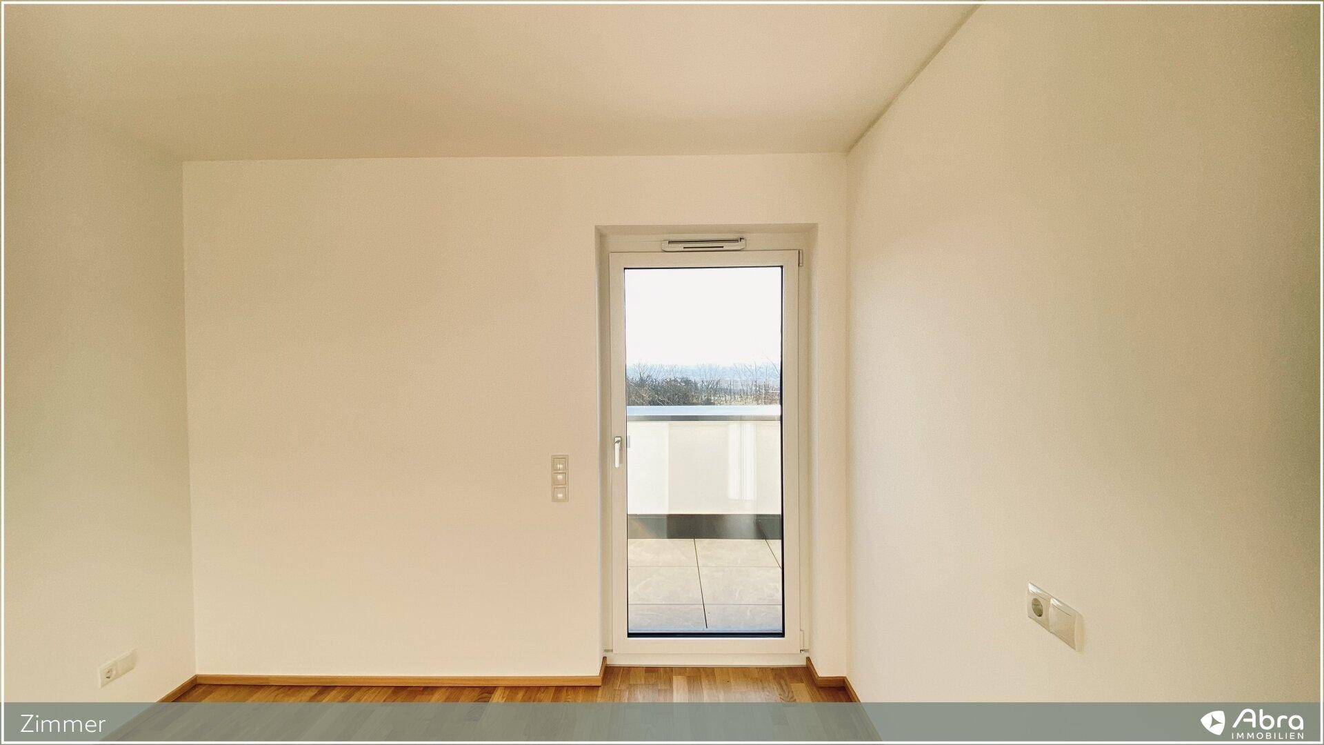 Geräumiges Zimmer mit Parkettboden und viel Tageslicht durch die Terrassentür, sehr einladend.