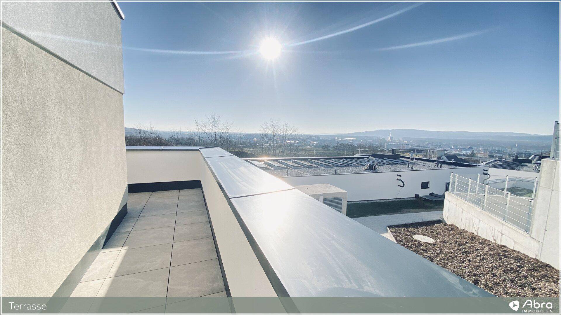 Sonnenterrasse mit Panoramablick über die Stadt und die umliegende Landschaft, sehr hell.
