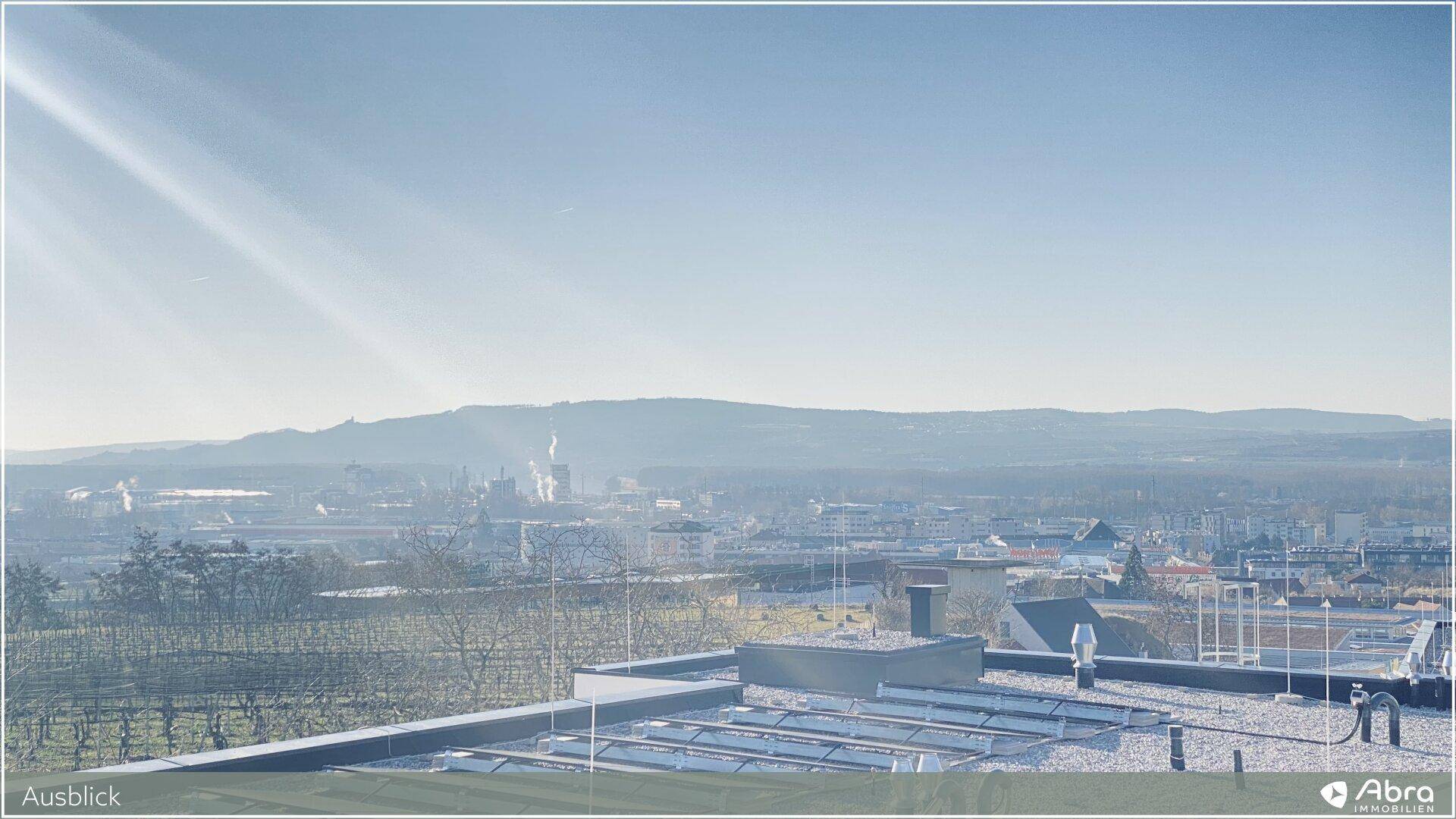 Weiter Panoramablick über die Stadt und die umliegende Landschaft mit Bergen im Hintergrund.