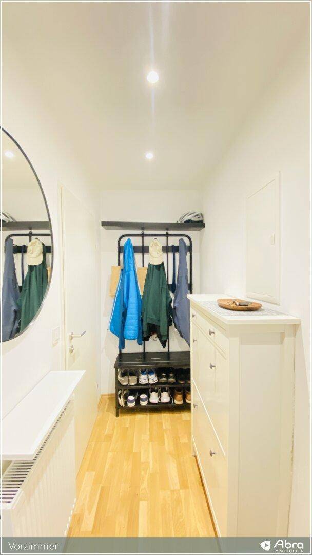 Heller Flur mit Garderobe, Schuhregal und Spiegel, bietet praktischen Stauraum am Eingang.