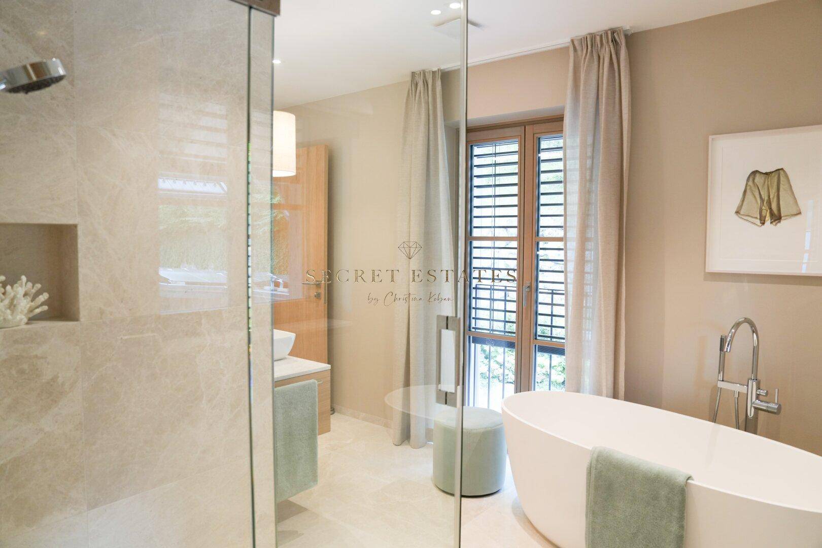 Modernes Badezimmer mit freistehender Badewanne, begehbarer Dusche und Marmorfliesen.