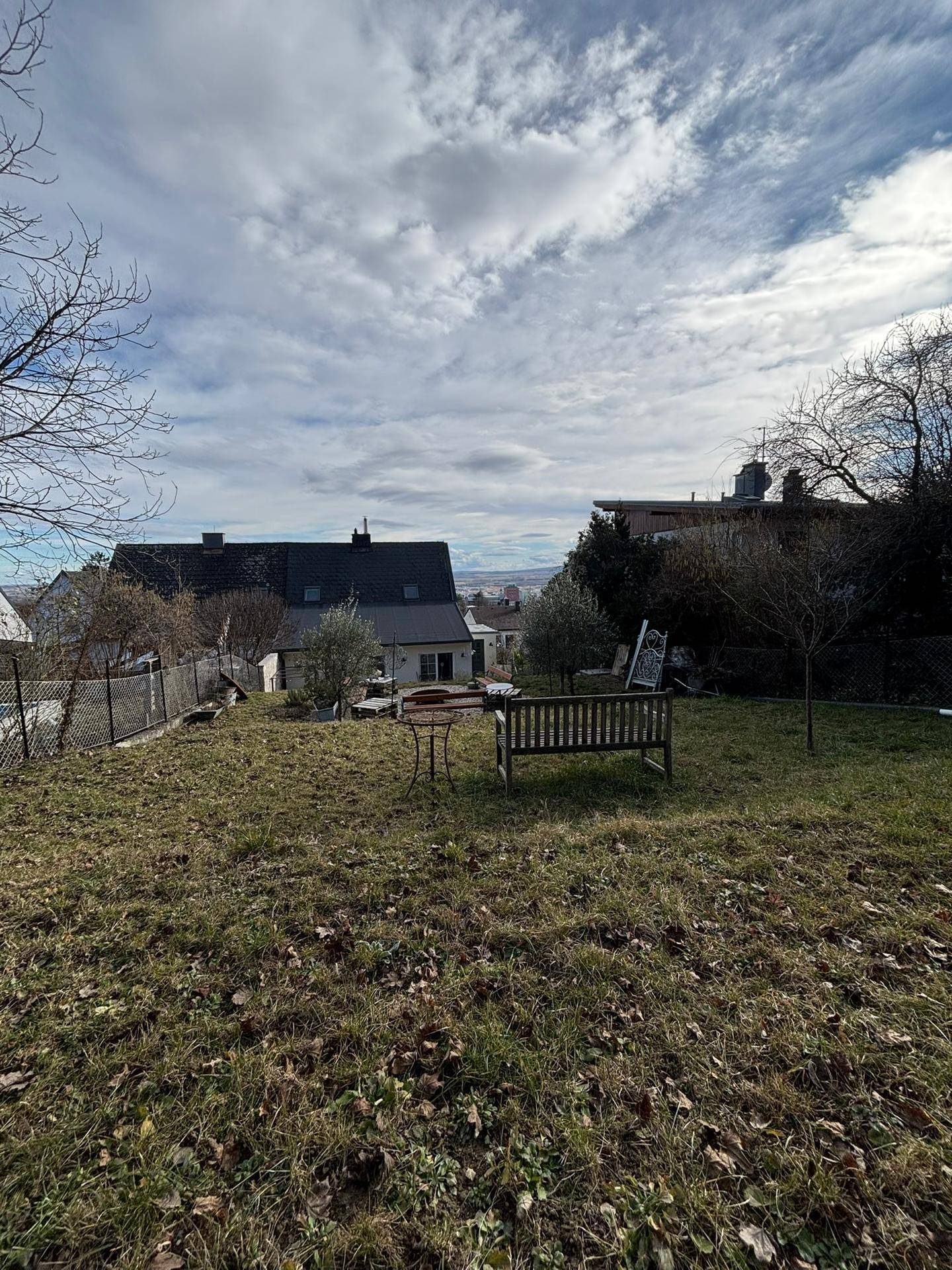 Großer Garten mit Rasenfläche, Sitzbank und weitem Blick über die Landschaft.