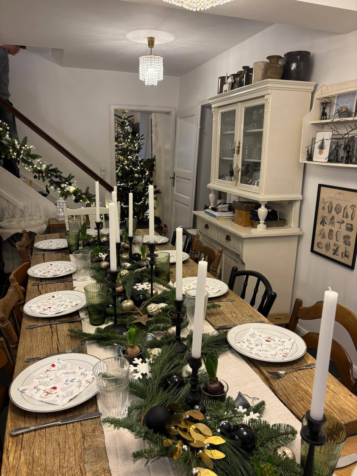 Festlich gedeckter Esstisch mit Kerzen und Weihnachtsdekoration in einem gemütlichen Esszimmer.