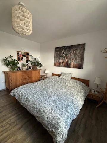 Schlafzimmer mit Doppelbett, Holzboden und Hirschmotiv an der Wand.